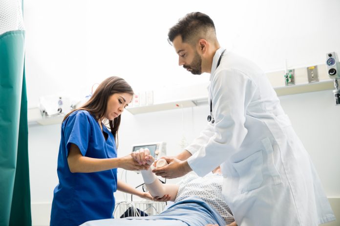 Good,Looking,Doctors,Putting,A,Bandage,On,A,Patient's,Arm